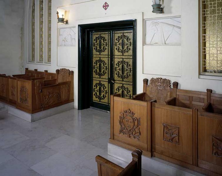 Chapelle du Bon Sauveur, vue intérieure : porte d'accès et stalles situées de part et d'autre de l'entrée.