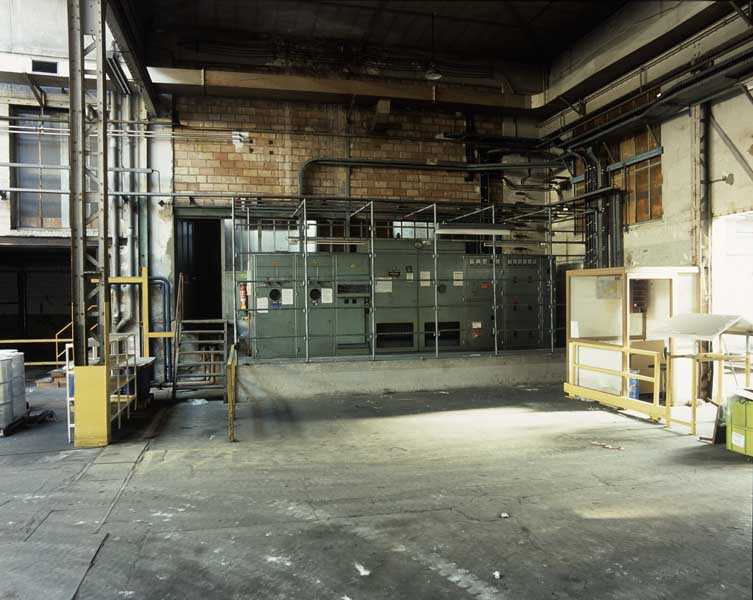 Bâtiment adossé à l'atelier de fabrication dit appareils à mains, abritant le moteur à combustion interne (accès par l'escalier gauche). Vue intérieure : tableau électrique.