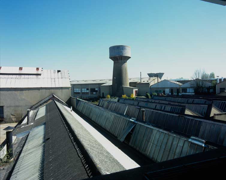 Ateliers de fabrication et château d'eau. Vue prise du nord, depuis la cantine (au 1er plan, dépôt A2, ou magasin des balances et magasin aciers).