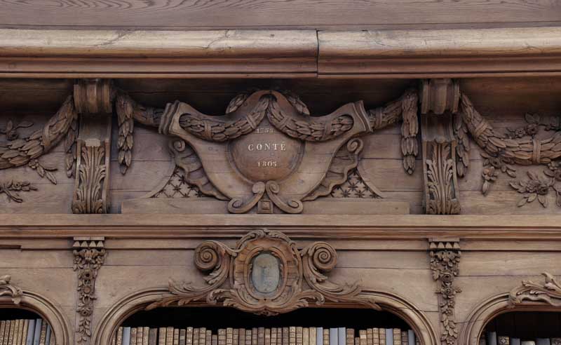 Etagère - bibliothèque de la salle du 1er étage, entablement à balustrades. Détail : médaillon au nom de Conté (1755-18056).