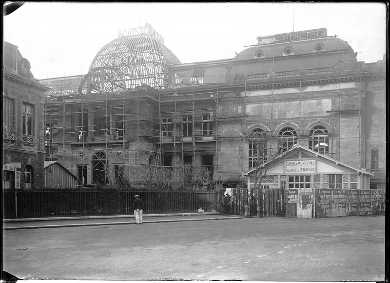 'Chantier de construction. Casino de Trouville. Vue prise de la place. Vue de la façade nord-est.- Photographie ancienne, n.s., n.d., 1911. Tirage n. et b. d''après plaque de verre gélatino-bromure d''argent (négatif), 13 x 18 cm. (Musée municipal, Villa Montebello, Trouville-sur-Mer. 006.1.27).'