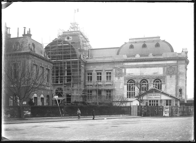 'Chantier de construction. Casino de Trouville. Vue prise de la place. Vue de la façade nord-est.- Photographie ancienne, n.s., n.d., 1912. Tirage n. et b. d''après plaque de verre gélatino-bromure d''argent (négatif), 13 x 18 cm. (Musée municipal, Villa Montebello, Trouville-sur-Mer. 006.1.50).'