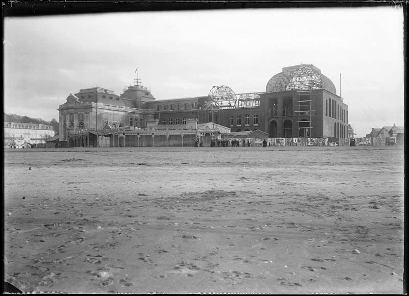 'Chantier de construction. Casino de Trouville. Vue prise de la plage. Vue d''ensemble de la façade nord-ouest.- Photographie ancienne, n.s., n.d., 1912. Tirage n. et b. d''après plaque de verre gélatino-bromure d''argent (négatif), 13 x 18 cm. (Musée municipal, Villa Montebello, Trouville-sur-Mer. 006.1.56).'