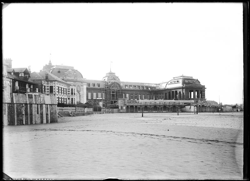 'Chantier de construction. Casino de Trouville. Vue de la plage. Vue d''ensemble de la façade nord-ouest.- Photographie ancienne, n.s., n.d., 1912. Tirage n. et b. d''après plaque de verre gélatino-bromure d''argent (négatif), 13 x 18 cm. (Musée municipal, Villa Montebello, Trouville-sur-Mer. 006.1.86).'