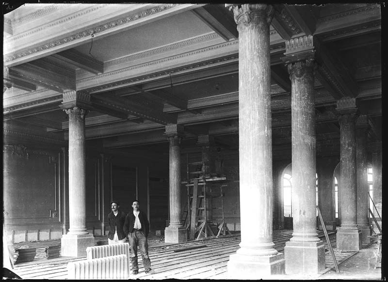 'Chantier de construction. Casino de Trouville. Vue intérieure, avec deux hommes sur le sol et un homme sur un échafaudage [rez-de-chaussée : n° 10].- Photographie ancienne, n.s., n.d., vers 1912. Tirage n. et b. d''après plaque de verre gélatino-bromure d''argent (négatif), 13 x 18 cm. (Musée municipal, Villa Montebello, Trouville-sur-Mer. 006.1.90).'