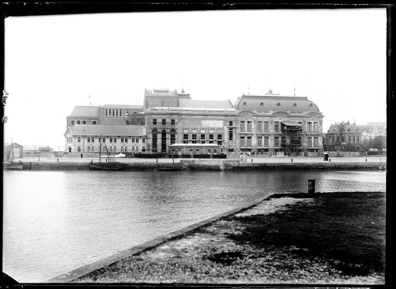 'Chantier de construction. Casino de Trouville. Vue prise de Deauville. Vue de la façade sud-est.- Photographie ancienne, n.s., n.d., 1912. Tirage n. et b. d''après plaque de verre gélatino-bromure d''argent (négatif), 13 x 18 cm. (Musée municipal, Villa Montebello, Trouville-sur-Mer. 006.1.99).'