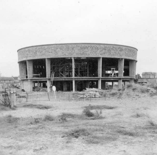 'Reconstruction du casino. Rotonde, vue d''ensemble prise du nord-est.- Photographie ancienne, n.s., 6 décembre 1956, [date manuscrite]. Tirage original sur papier brillant contrecollé sur carton, n. et b., 6,2 x 6,2 cm. (AC Ouistreham).'