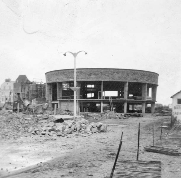 Reconstruction du casino. Rotonde, vue prise du sud-est.- Photographie ancienne, n.s., 1er janvier 1957, [date manuscrite]. Tirage original sur papier brillant contrecollé sur carton, n. et b., 6,2 x 6,2 cm. (AC Ouistreham).