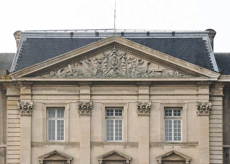 Avant-corps central du bâtiment de l'administration prise du nord. Baies et fronton aux armes de l'Empire.
