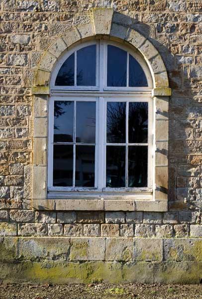 Bâtiment dit 'le Médico' (bâtiment qui accueillait à l'origine des enfants, puis les caves, puis des ateliers, aujourd'hui lieu de stockages divers). Elévation est. Détail : fenêtre du rez-de-chaussée de la façade.