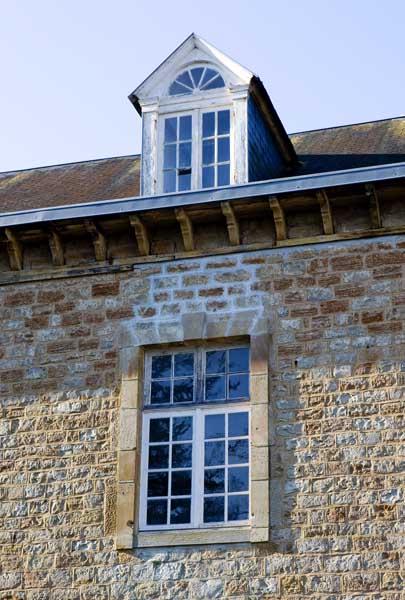 Bâtiment dit 'le Médico' (bâtiment qui accueillait à l'origine des enfants, puis les caves, puis des ateliers, aujourd'hui lieu de stockages divers). Elévation est. Détail : fenêtre du 1er étage et lucarne.