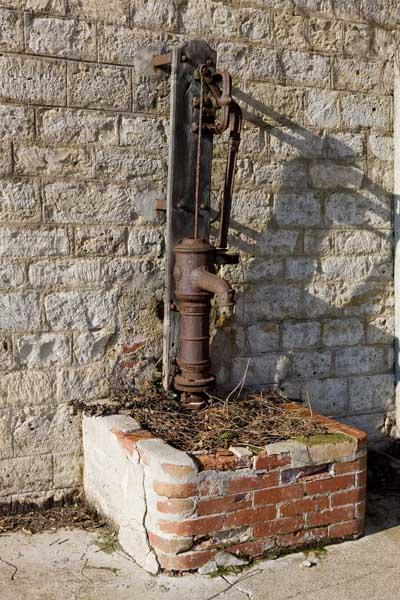 Bâtiment dit 'Lourdes'. Cour : pompe à eau.