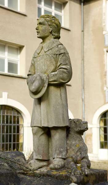 Bâtiment de la Maison de retraite 'Elisabeth de Surville', anciennement bâtiment de la Communauté. Monument du Centenaire (1937), situé dans la cour. Détail d'une figure latérale (jeune garçon).