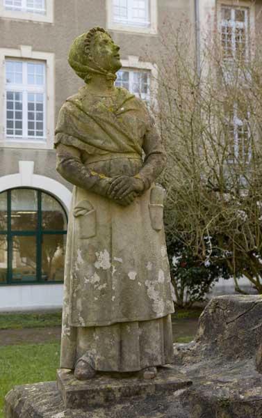 Bâtiment de la Maison de retraite 'Elisabeth de Surville', anciennement bâtiment de la Communauté. Monument du Centenaire (1937), situé dans la cour. Détail d'une figure latérale (jeune fille).