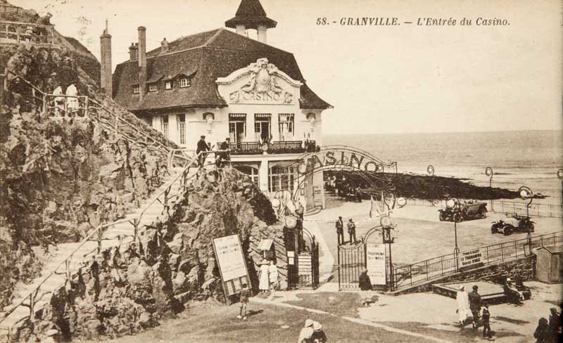 '58. - Granville. - L''Entrée du Casino. [Vue prise de l''est, 3e casino].- Carte postale, n.d., entre 1911 et 1925 [date d''aménagement de la place], n. et b., 17,7 x 8,8 cm. (Musée du Vieux Granville, Granville).'