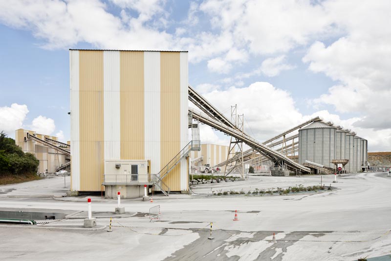 Silos reliés par un système de convoyage au bâtiment de chargement des camions, vue de l'ouest.