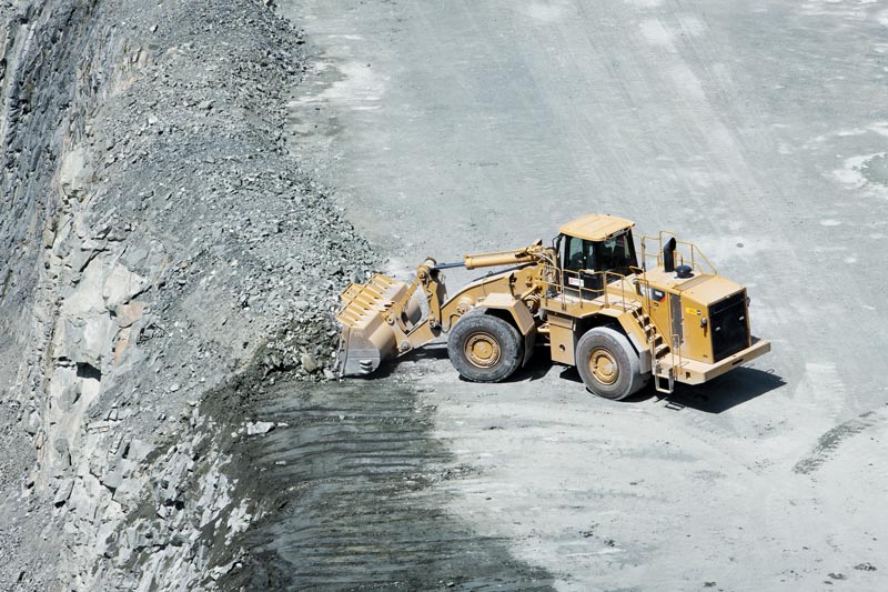 Pelle dégageant le flanc ayant été travaillé au tir de mine.