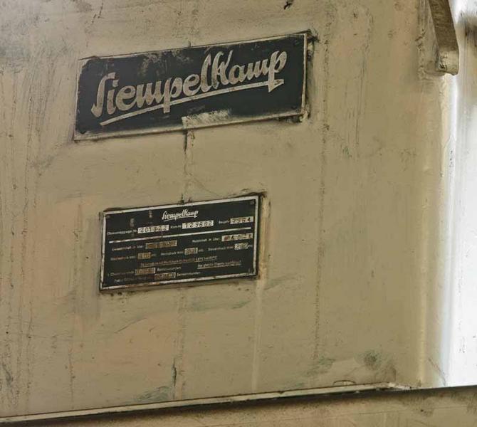Détail de la presse Siempelkamp, inscription concernant le fabriquant et plaque signalétique.