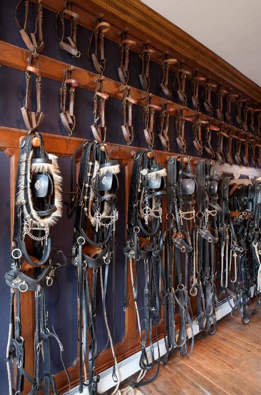 Vue partielle de la sellerie d'honneur : harnais de poste pour attelage à quatre chevaux.