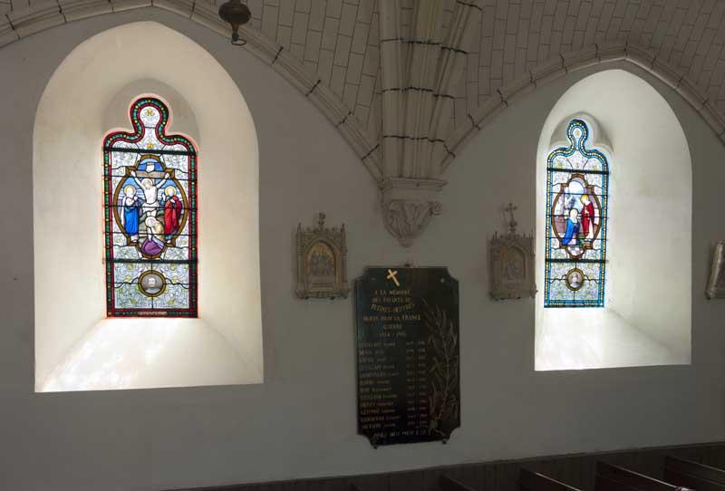 Vue d'ensemble des baies 8 et 10 sur le mur sud de la nef : entre les deux baies, une plaque commémorative en marbre noir liste les noms des victimes de la Grande Guerre.