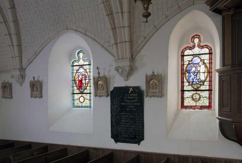 Vue d'ensemble des baies 7 et 9 sur le mur nord de la nef : entre les deux baies, une plaque commémorative en marbre noir liste les noms des victimes de la Grande Guerre.