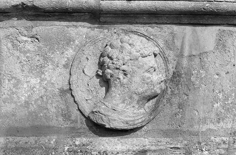 Façade ouest, médaillon sous la fenêtre du rez-de-chaussée située à gauche de la porte.