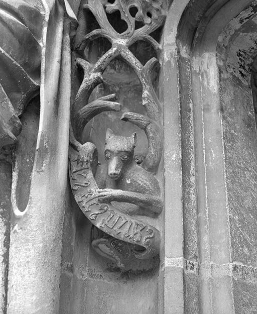 Décor sculpté (animal tenant une banderole avec une inscription).
