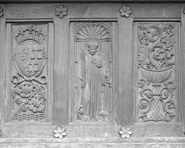 Portail flamboyant. Décor sculpté de la porte de droite (saint Pantaléon entre un blason et un calice).