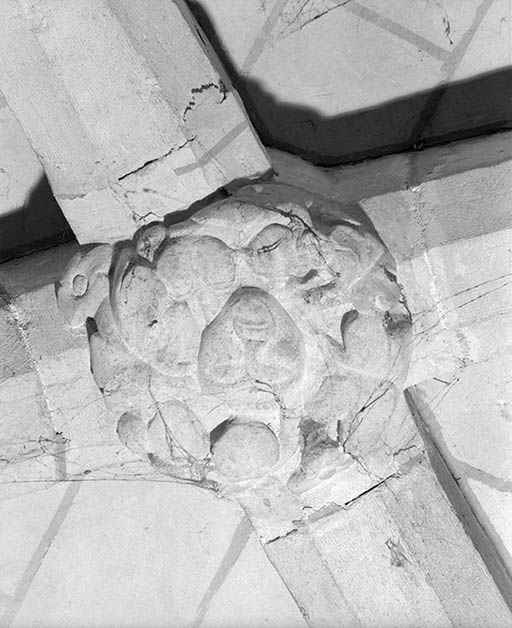Clef de voûte sculptée, avec visage grossier.