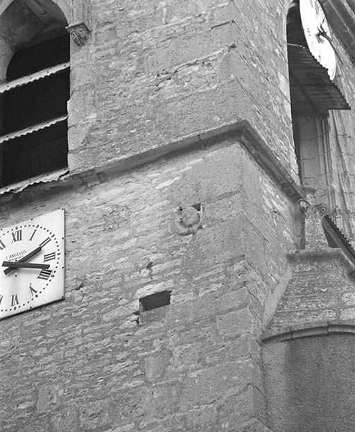 Détail de la tête humaine sculpté sur le mur antérieur du clocher.