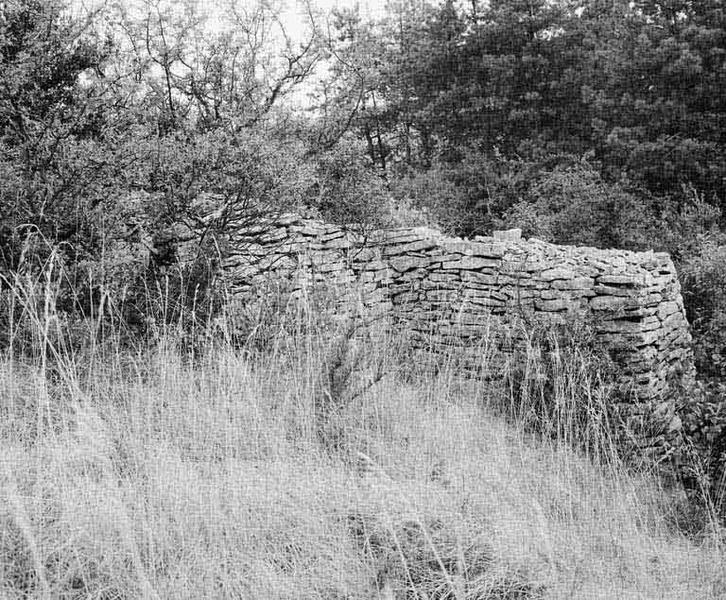 Cabane et mur de clôture.