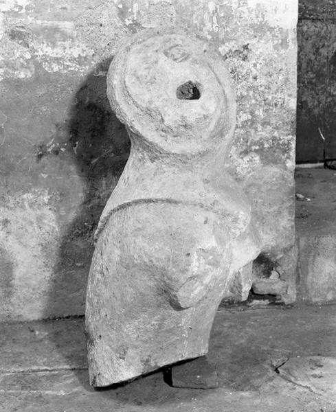 Gargouille en forme de personnage déposée dans la nef, trois-quarts.