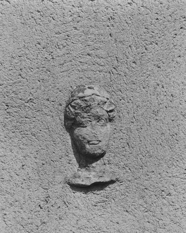 Relief : tête sculptée.