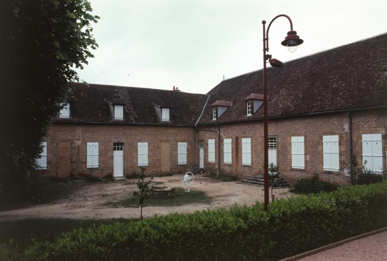 Vue d'ensemble du bâtiment : ancienne salle des malades et cour.