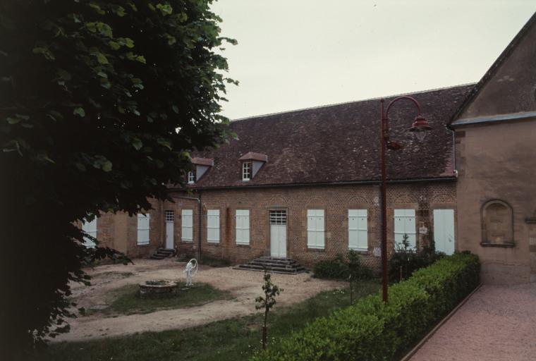 Vue d'ensemble du bâtiment : ancienne salle des malades et cour.