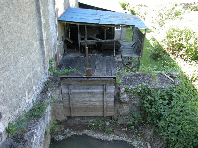 Vue arrière du bâtiment de l'ancienne forge transformée en moulin puis logements. Place du bief et de l'ancienne turbine.