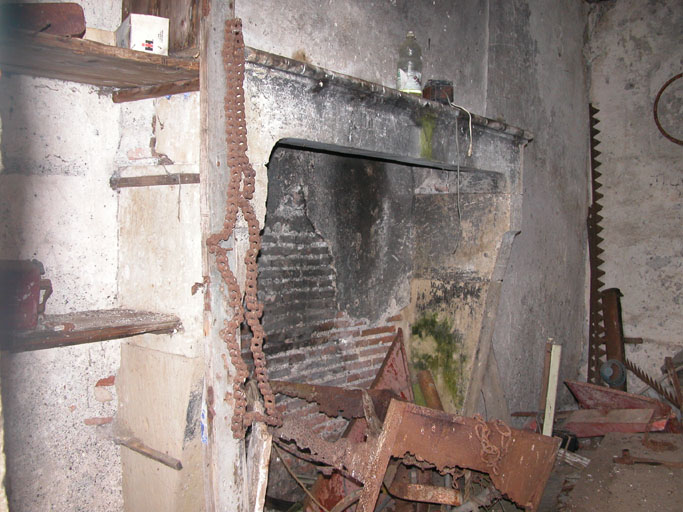 Vue de l'intérieur d'un logement d'ouvriers avec la présence d'une cheminée.
