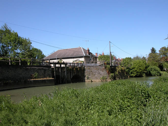 Vue générale par la rivière avec le moulin à l'arrière.