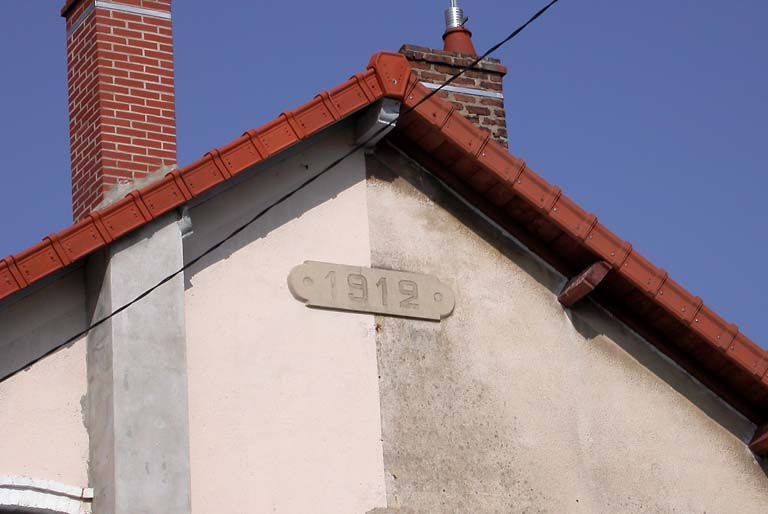 Détail d'un pignon de maison jumelée, porte la date.