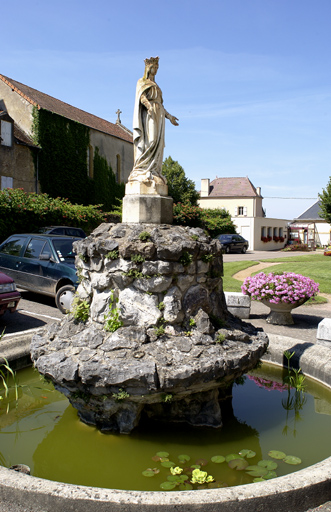 Bassin et statue de la Vierge dans le jardin.