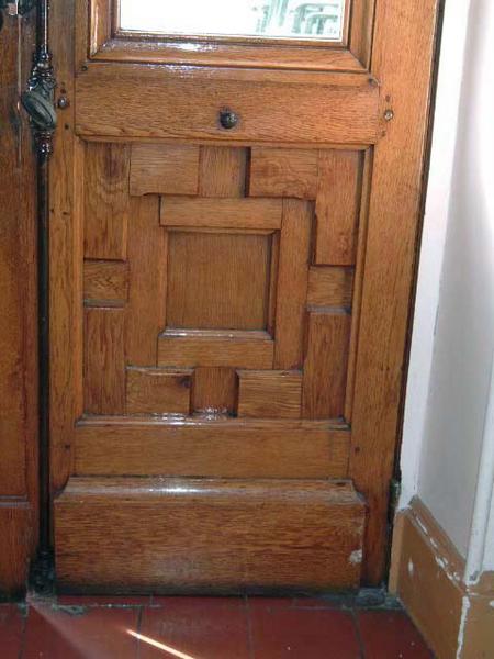 Vue de détail d'un panneau bois d'une porte d'entrée, assemblage vu de l'intérieur du bâtiment.