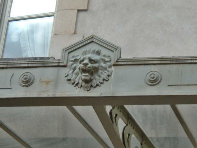 Vue de détail du mascaron (tête de lion) de la galerie extérieure à structure métallique (fonte).