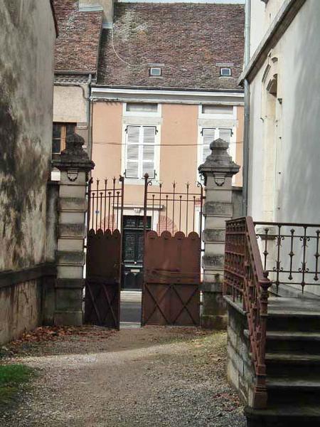 Vue du portail, de la grille et de l'escalier en fonte de l'entrée située sur la façade postérieure de l'établissement.