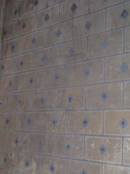 Vue de détail de la peinture murale de l'oratoire (décor polychrome faux joints et fleurette).