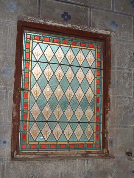Vue de détail du vitrail de l'oratoire (décor géométrique et végétal stylisé).