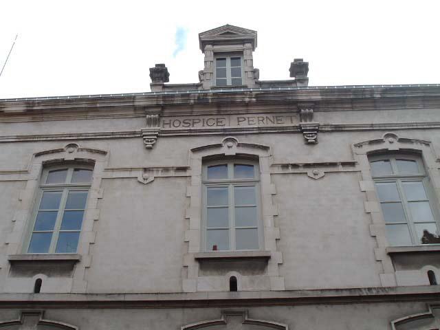 Vue de détail de la façade postérieure, étage carré, inscription HOSPICE PERNET.