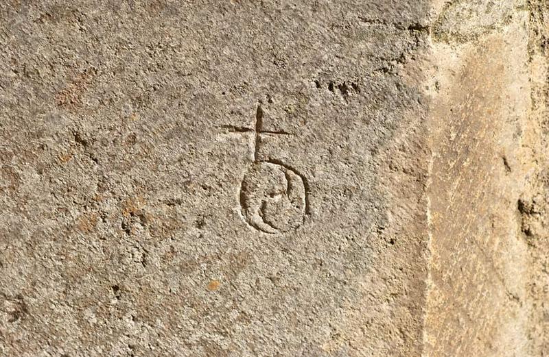 Marque de tâcheron sur le mur gauche du porche.