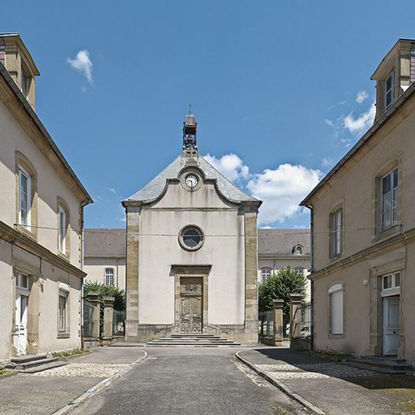 Façade de la chapelle entre les deux bâtiments bordant l'allée.