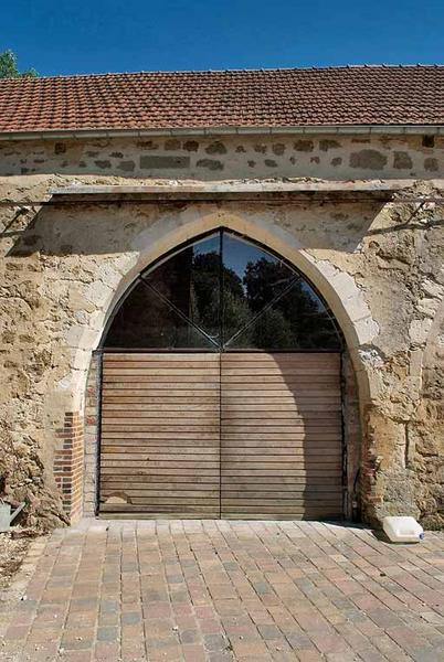Chapelle : arcade transformée en porte du mur de long-pan sur cour.