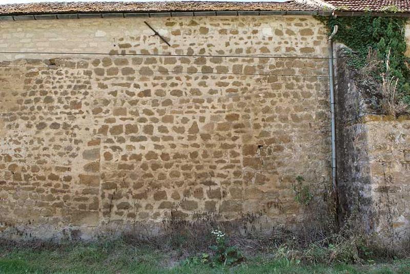 Hangar : mur postérieur sur rue avec traces d'un ancien portail.